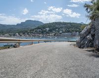 a paved road beside some large boats and a bridge with a bridge to the water