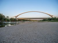 there are two very long bridges that are above the river shore at dusk here, and you can see how close them are