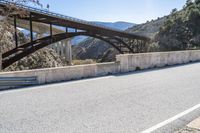 a road, with a pedestrian bridge crossing over the hill on both sides of it