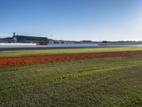 the green road and orange and white stripe line at an event near the racetrack and stadium