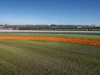 the green road and orange and white stripe line at an event near the racetrack and stadium