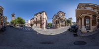 a fish eye view of an empty street in a town with many shops and houses