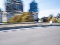 a photo taken of the speeding car in traffic on a highway with large buildings in the background