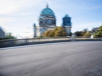 a photo taken of the speeding car in traffic on a highway with large buildings in the background