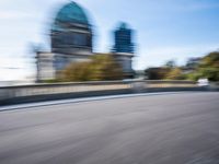 a photo taken of the speeding car in traffic on a highway with large buildings in the background