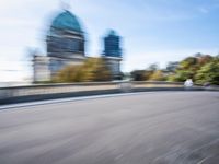 a photo taken of the speeding car in traffic on a highway with large buildings in the background