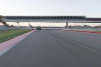 a speeding motor vehicle in motion at the start of an empty track under an overpass