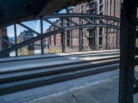 view from a train platform, looking at buildings and railroad tracks with graffiti on the outside