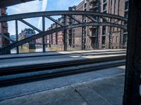 view from a train platform, looking at buildings and railroad tracks with graffiti on the outside