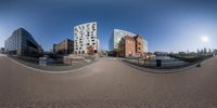 two buildings are seen in a spherical video taken from the other side of a road