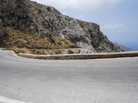 a person is riding down the road on a bike in front of a mountain side