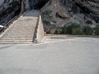 stairs going up to the side of a steep hill in a cliff type area with a white bicycle