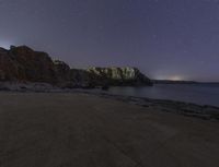 a photo of a view at night in the sky of a bay, a beach, and the sky is dark