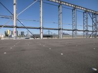 a view of a steel frame and a train in the distance from an airport parking lot