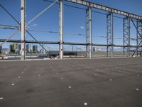 a view of a steel frame and a train in the distance from an airport parking lot