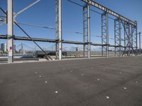 a view of a steel frame and a train in the distance from an airport parking lot