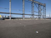 a view of a steel frame and a train in the distance from an airport parking lot