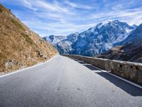 road winding with snow capped mountains on the background for a travel background image or wallpaper