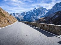 road winding with snow capped mountains on the background for a travel background image or wallpaper