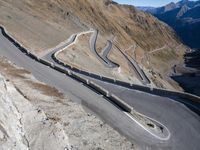 the view from a bird eye point on the winding mountain road with curves going through the mountain ranges