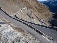 the view from a bird eye point on the winding mountain road with curves going through the mountain ranges