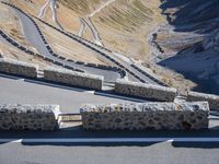 the bike rider is riding down the steep slope of a mountain road towards a valley