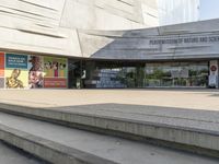 steps going up to a museum where two people are standing on each side of them