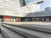 steps going up to a museum where two people are standing on each side of them