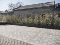 stone and stone patio area with plants growing outside and large grey planter boxes on top