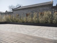 stone and stone patio area with plants growing outside and large grey planter boxes on top