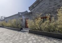 stone and stone patio area with plants growing outside and large grey planter boxes on top