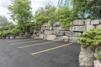 a parking lot that has a stone wall around it to provide a parking spot for the cars