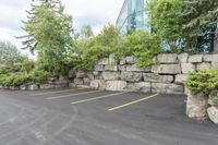 a parking lot that has a stone wall around it to provide a parking spot for the cars