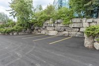 a parking lot that has a stone wall around it to provide a parking spot for the cars