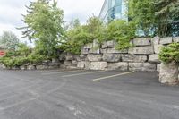 a parking lot that has a stone wall around it to provide a parking spot for the cars