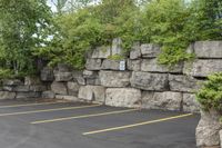 a parking lot that has a stone wall around it to provide a parking spot for the cars