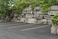 a parking lot that has a stone wall around it to provide a parking spot for the cars