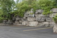 a parking lot that has a stone wall around it to provide a parking spot for the cars