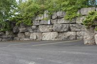 a parking lot that has a stone wall around it to provide a parking spot for the cars