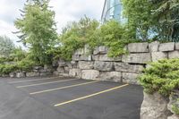 a parking lot that has a stone wall around it to provide a parking spot for the cars