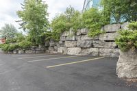 a parking lot that has a stone wall around it to provide a parking spot for the cars