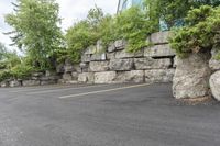 a parking lot that has a stone wall around it to provide a parking spot for the cars