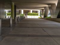 an empty walkway leading from an office building into the city below it and surrounding the plants and trees