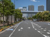 empty road with white lines on the streets of city area against cloudy blue sky on a sunny day