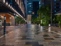 a large brick sidewalk with a store front at night time and a sign that says