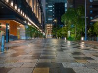 a large brick sidewalk with a store front at night time and a sign that says