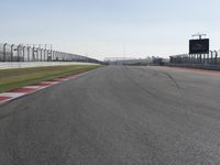 an empty track at a motorsports club with some red and white stripeing on it