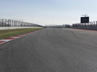 an empty track at a motorsports club with some red and white stripeing on it