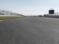 an empty track at a motorsports club with some red and white stripeing on it