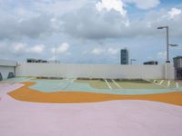 a roof with an open air park with a colorful mural on the pavement below some building